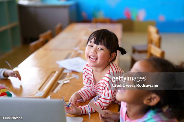 girl kids laughing together while playing in classroom - plat thai stock pictures, royalty-free photos & images