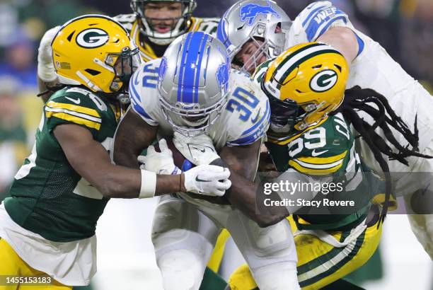 Jamaal Williams of the Detroit Lions is tackled by Ifeatu Melifonwu and De'Vondre Campbell of the Green Bay Packers during the fourth quarter at...