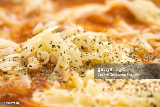 close up of shredded mozzarella cheese - pizza crispy stock-fotos und bilder