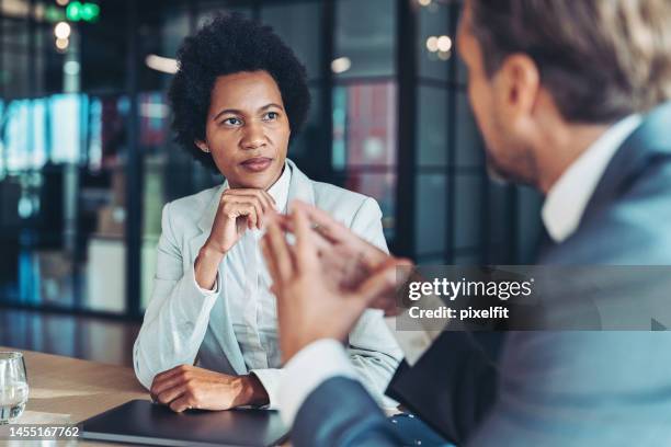 middle aged businesswoman in a conversation with a colleague - serious discussion stock pictures, royalty-free photos & images