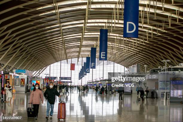 Passengers with suitcases prepare to board an aircraft at Shanghai Pudong International Airport during the Spring Festival travel rush on January 8,...