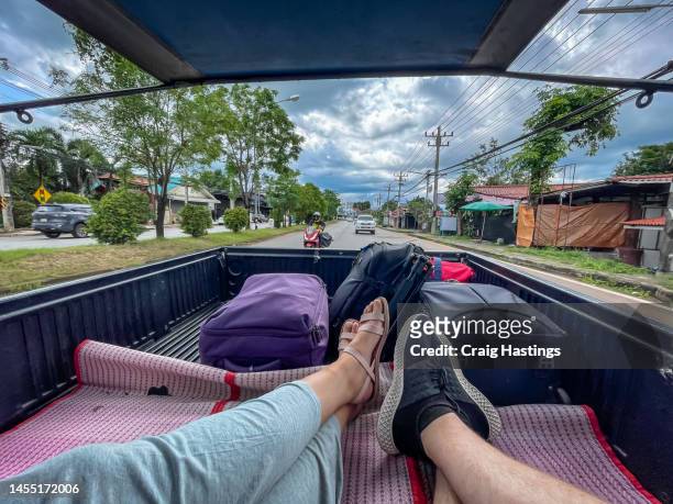 middle aged couple riding in the back of truck in southeast asia. concept for adventure, career break, fun, travel, backpacking and tourism - gap year stock pictures, royalty-free photos & images