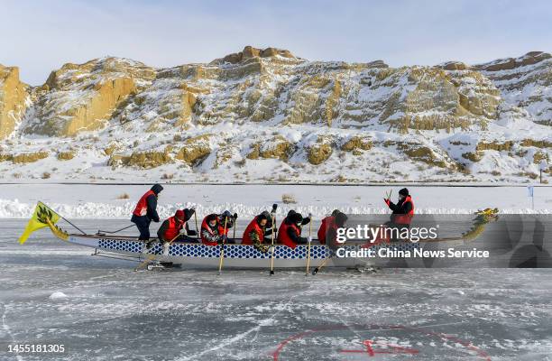 Racers compete on a 400-meter round ice track during an ice dragon boat race on the frozen Ulungur Lake on January 8, 2023 in Fuhai County, Altay...