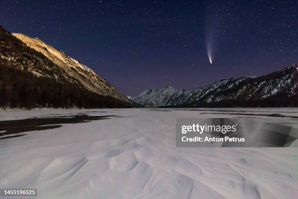 comet  c/2022 e3 (ztf) at night over winter mountains - comet fotografías e imágenes de stock