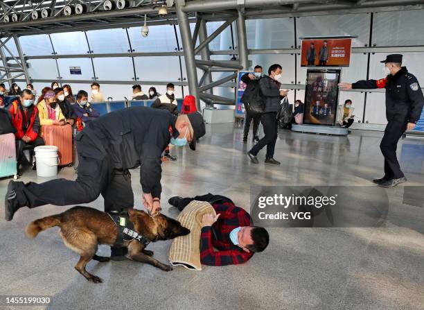 Police officers with a dog perform drills during a demonstration at Nantong Railway Station one day before the 3rd Chinese People's Police Day on...