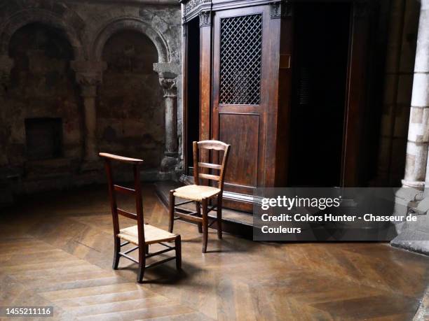 two empty chairs in front of a confessional in a church in paris - church color light paris stockfoto's en -beelden