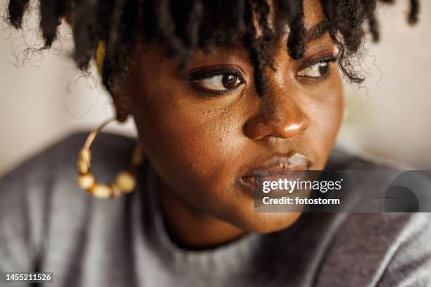 mujer joven mirando hacia otro lado, contemplando sus propósitos de año nuevo - mujer pensativa seria fotografías e imágenes de stock