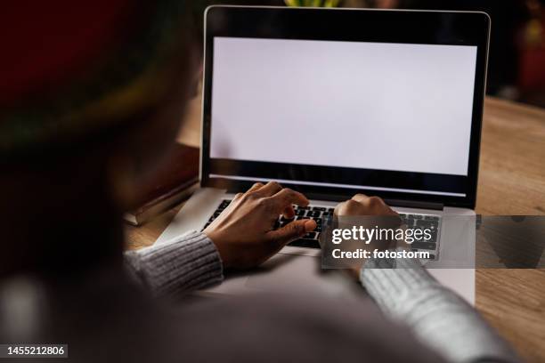 junge frau tippt daten auf einem laptop mit leerem, weißem bildschirm - woman laptop screen stock-fotos und bilder