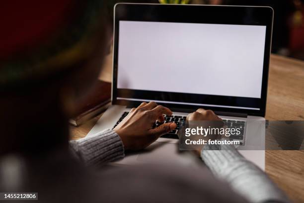 young woman typing data on a laptop with blank, white screen - hands behind back bildbanksfoton och bilder