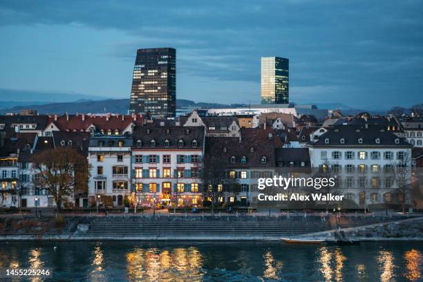 historic and modern buildings of the wettstein district glow at night in basel, switzerland. - basel switzerland stock pictures, royalty-free photos & images