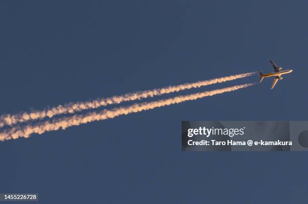 the airplane flying in the sunset sky over kanagawa of japan - trace avion ciel photos et images de collection