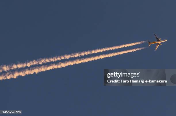 the airplane flying in the sunset sky over kanagawa of japan - sunset with jet contrails stock pictures, royalty-free photos & images