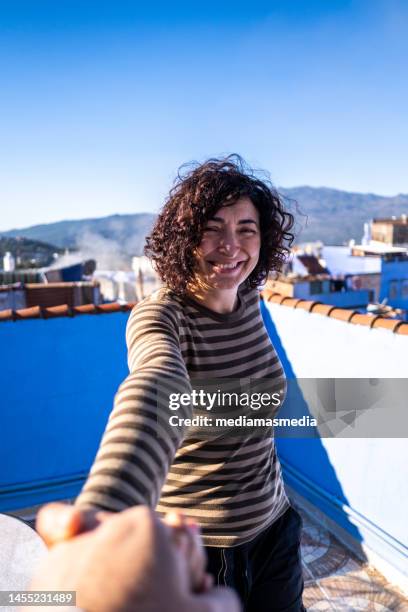 adult woman leads another person across the terrace of a tourist apartment at a travel destination. point of view pov. traveling with a companion makes you feel more confident in unfamiliar situations. - dating game stock pictures, royalty-free photos & images