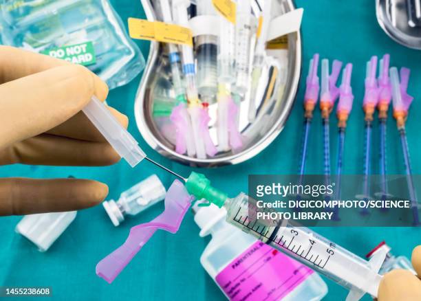 nurse preparing a needle with a safety mechanism - injecting iv stock pictures, royalty-free photos & images