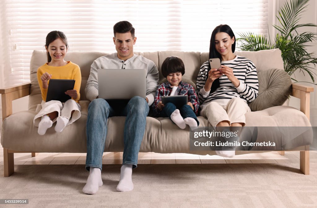 Internet Addiction Family With Different Gadgets On Sofa At Home High ...