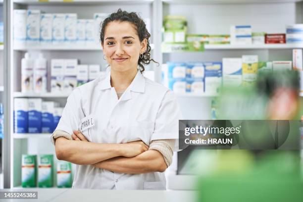 portrait of a confident young female pharmacist with arms crossed - smirking stock pictures, royalty-free photos & images