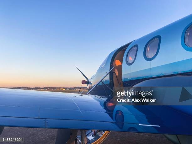 parked single engine turboprop propeller aircraft at sunset. - small plane stock pictures, royalty-free photos & images