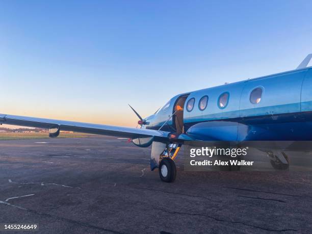 parked single engine turboprop propeller aircraft at sunset. - sunset society stock-fotos und bilder