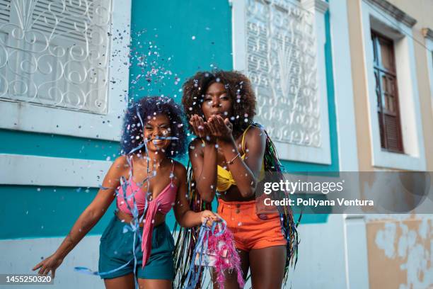 bailarines soplando confeti en el carnaval callejero - carnaval fotografías e imágenes de stock