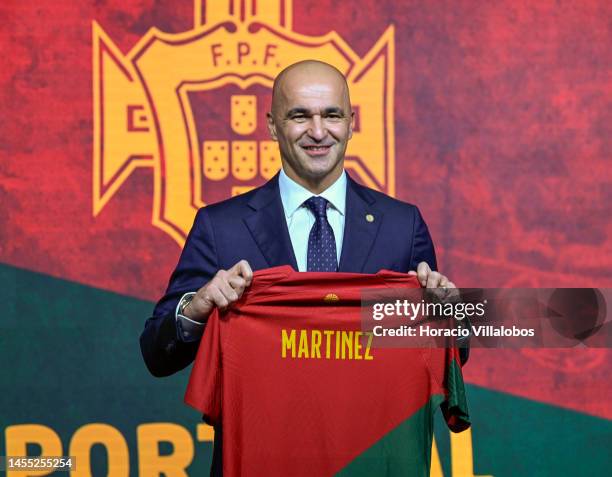Roberto Martinez smiles while posing for pictures with a national team jersey with his name during his presentation as new national Soccer Team coach...