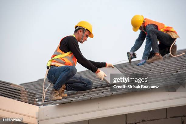 working on the roof structure of the building on the construction site, roofer - dakdekker stockfoto's en -beelden