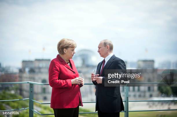 In this photo provided by the German Government Press Office , German Chancellor Angela Merkel welcomes Russia's President Vladimir Putin with...