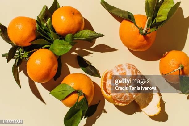 colorful fruit pattern of fresh mandarin tangerine or clementine on beige background. healthy food, diet and detox concept. flat lay, top view, copy space - mandarijn stockfoto's en -beelden