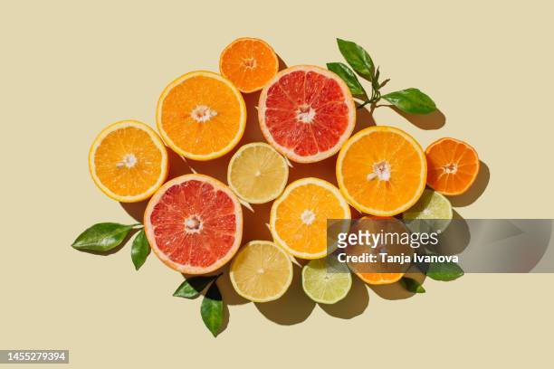 pattern of slices citrus-fruit of lemons, oranges, grapefruit, lime on beige background. healthy food, diet and detox concept. flat lay, top view - orange fruit 個照片及圖片檔