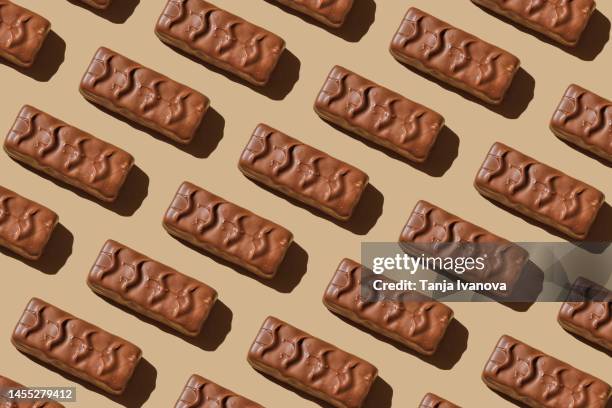 pattern of chocolate bars on beige background. flat lay, top view - chocolate top view stock-fotos und bilder