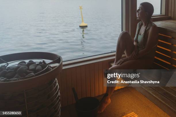 woman contemplating sauna time with view of the sea in norway - steam room stock pictures, royalty-free photos & images