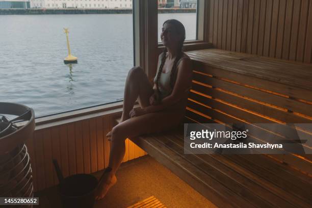 frau, die über saunazeit mit blick auf das meer in norwegen nachdenkt - more stock-fotos und bilder
