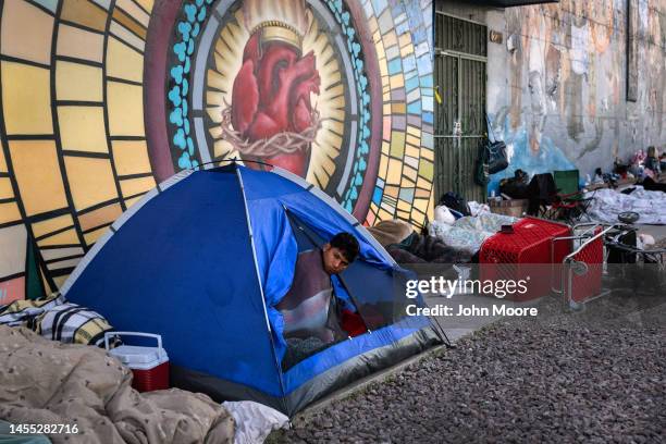 Immigrants awake after spending the night sleeping outside a migrant shelter on January 9, 2023 in El Paso, Texas. President Joe Biden visited El...