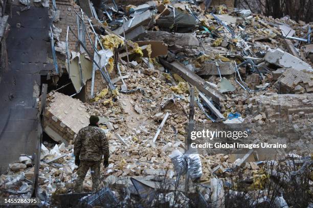 Ukrainian military man looks at the "Alfavito" hotel, partially destroyed by a missile strike on January 3, 2023 in Kyiv, Ukraine. On December 31, on...