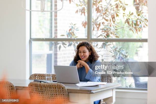 mujer adulta mediana usa computadora portátil para videollamar a la familia - usar el ordenador fotografías e imágenes de stock