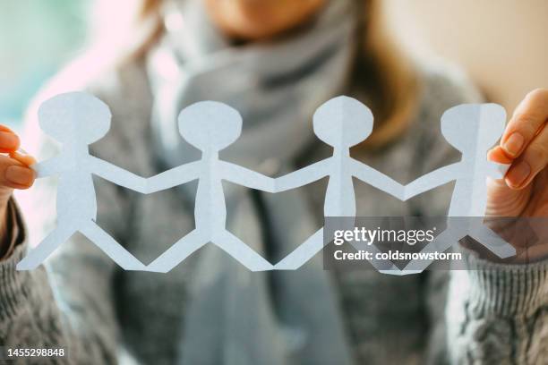 woman holding human paper chain - paper man stock pictures, royalty-free photos & images