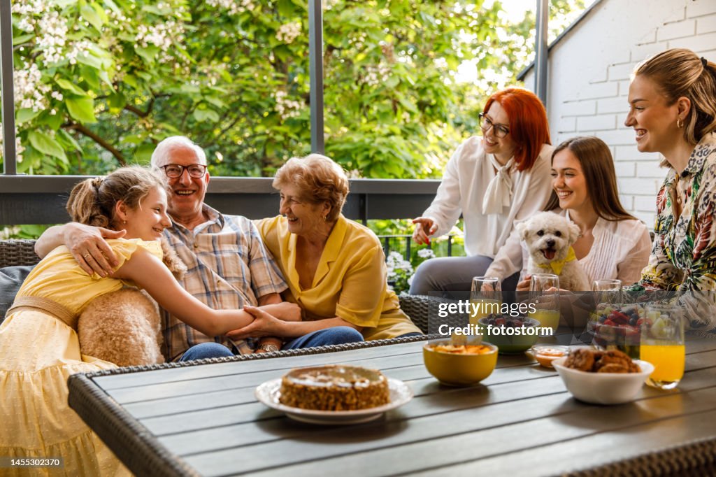 Multi-generation family having bonding moments during a celebration on the balcony