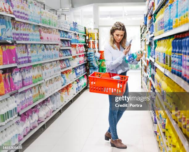 woman with shopping basket buying groceries in supermarket - cleaning product 個照片及圖片檔