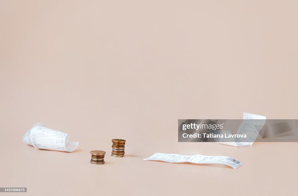 Cost of living. Сoins and payment receipts. Abstract minimalistic composition with copy space. World crisis, stagnation, inflation, and rising of prices concept