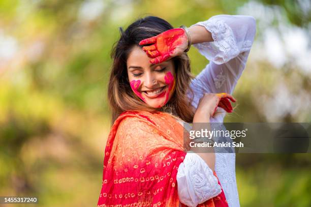 a beautiful girl celebrating holi with colours - woman holi stock pictures, royalty-free photos & images
