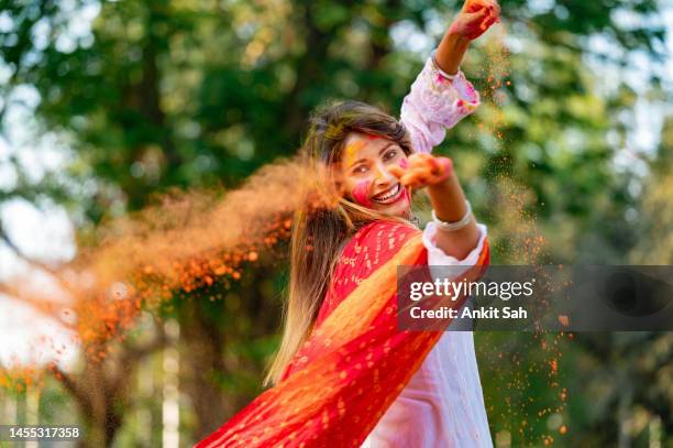 happy young beautiful girl playing with colours on the occasion of holi festival - indian dance stock pictures, royalty-free photos & images