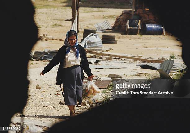 Palestinian refugee carrying a bag of vegetables at the Bourj el-Barajneh camp in Beirut, Lebanon, during the Lebanese Civil War, 1989.
