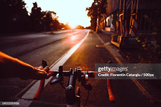 cropped hand of woman riding bicycle on road,romania - アクション映画 ストックフォトと画像