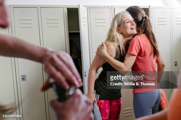 female friends greeting each other at gym - orange vest stock pictures, royalty-free photos & images