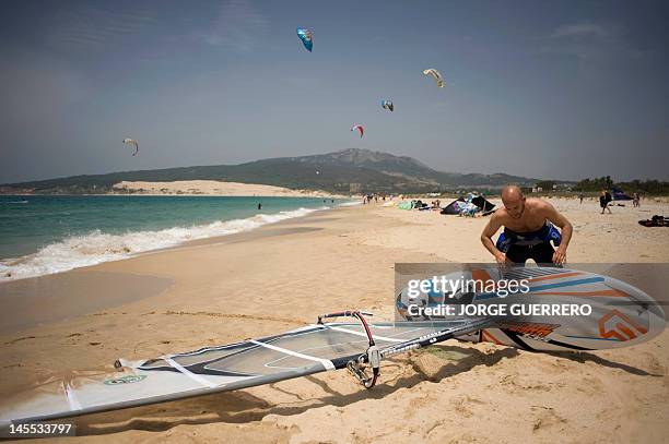 Un projet de bétonnage menaçant une plage paradisiaque indigne en Espagne" A windsurfer prepares himself before riding waves at Valdevaqueros beach...