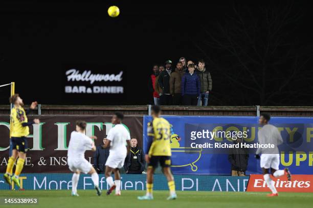 Fans watch match action from outside the stadium during the Emirates FA Cup Third Round match between Oxford United and Arsenal at Kassam Stadium on...