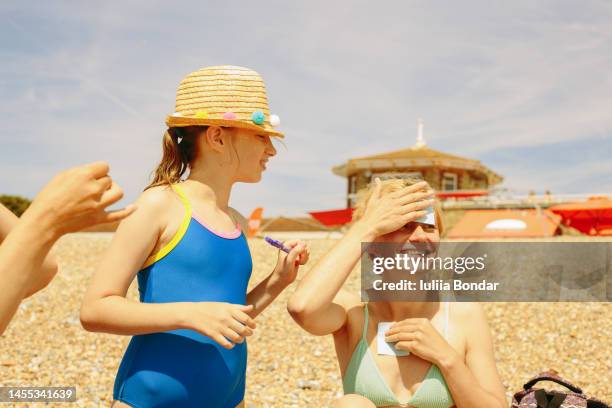 mother and daughter playing guess game - tween girls swimwear stock pictures, royalty-free photos & images