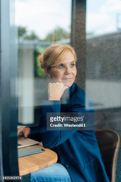 thoughtful smiling businesswoman in soundproof cabin - office cabin stockfoto's en -beelden