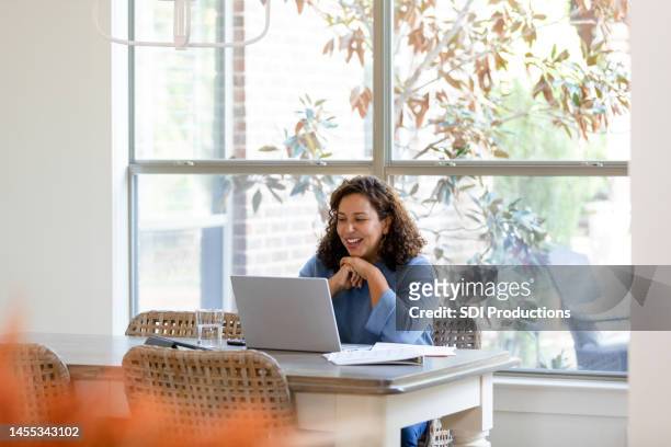 mid adult woman talks during a virtual meeting - financial advisor virtual stock pictures, royalty-free photos & images