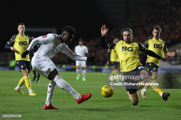 Bukayo Saka of Arsenal shoots under pressure from Ciaron Brown of Oxford United during the Emirates FA Cup Third Round match between Oxford United...