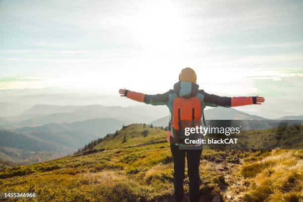 female hiker standing  with arms outstretched and enjoying the view on mountain peak - balkans stock pictures, royalty-free photos & images